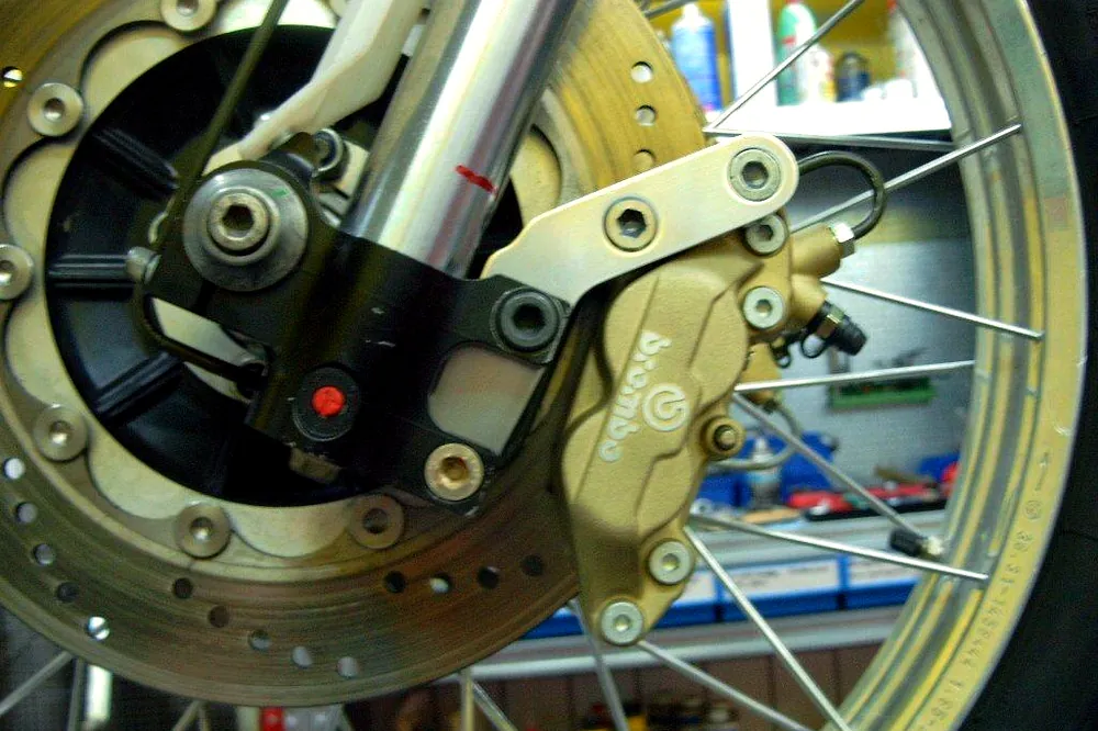 Goldener Brembo-Bremssattel an einem Motorrad-Speichenrad