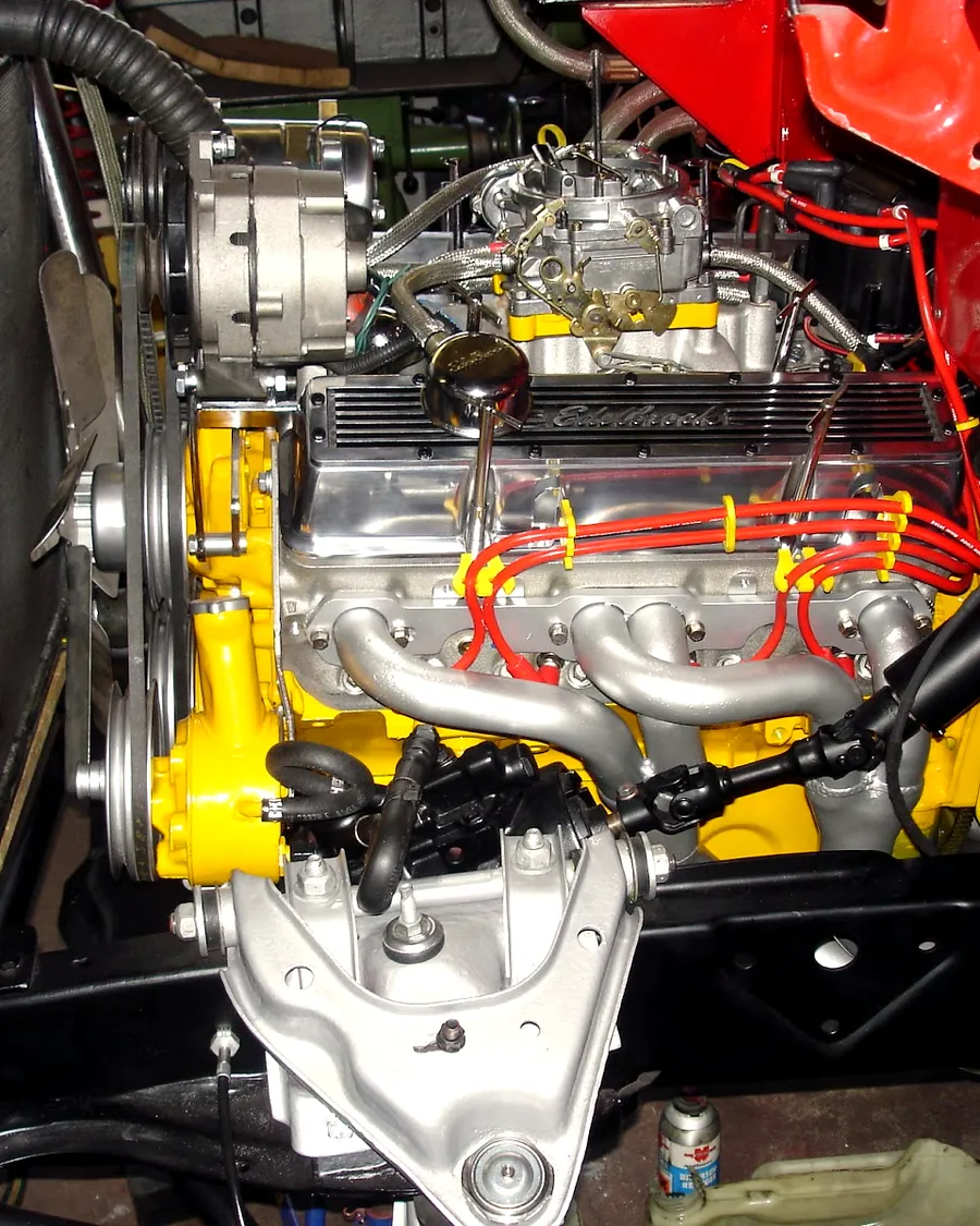 Frisch aufgebauter, gelb lackierter US-V8-Motor auf dem Montagebock in der Restaurationswerkstatt